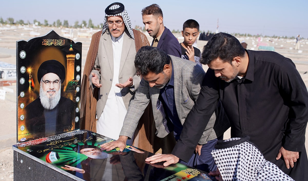عراقيون يقرأون الفاتحة على ضريح رمزي للسيد الشهيد حسن نصرالله في النجف (أ ف ب)