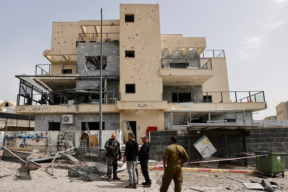 خلال تفقد مبنى في كريات شمونة بعد إصابته بصاروخ لحزب الله (أ ف ب)