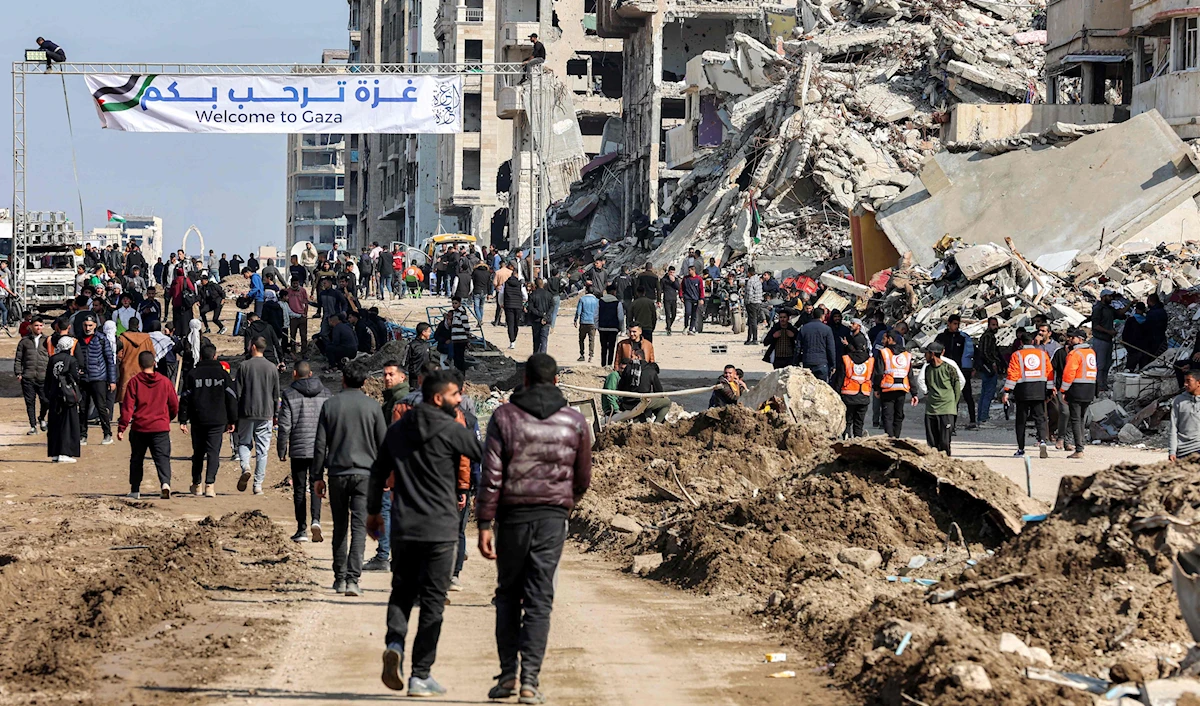 افترش غزيون الأرض على مدخل وادي غزة، في انتظار انسحاب الجيش الإسرائيلي من حاجز نتساريم (أ ف ب)