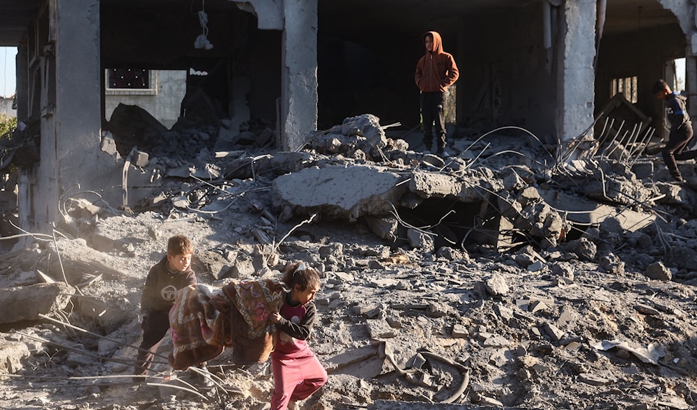 أطفال فلسطينيون وسط الدمار بعد هجوم إسرائيلي على مخيم المغازي وسط قطاع غزة (أ ف ب)