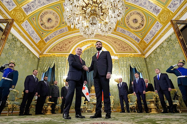 بوتين مصافحاً الشرع في بداية اجتماعهما في الكرملين (أ ف ب)