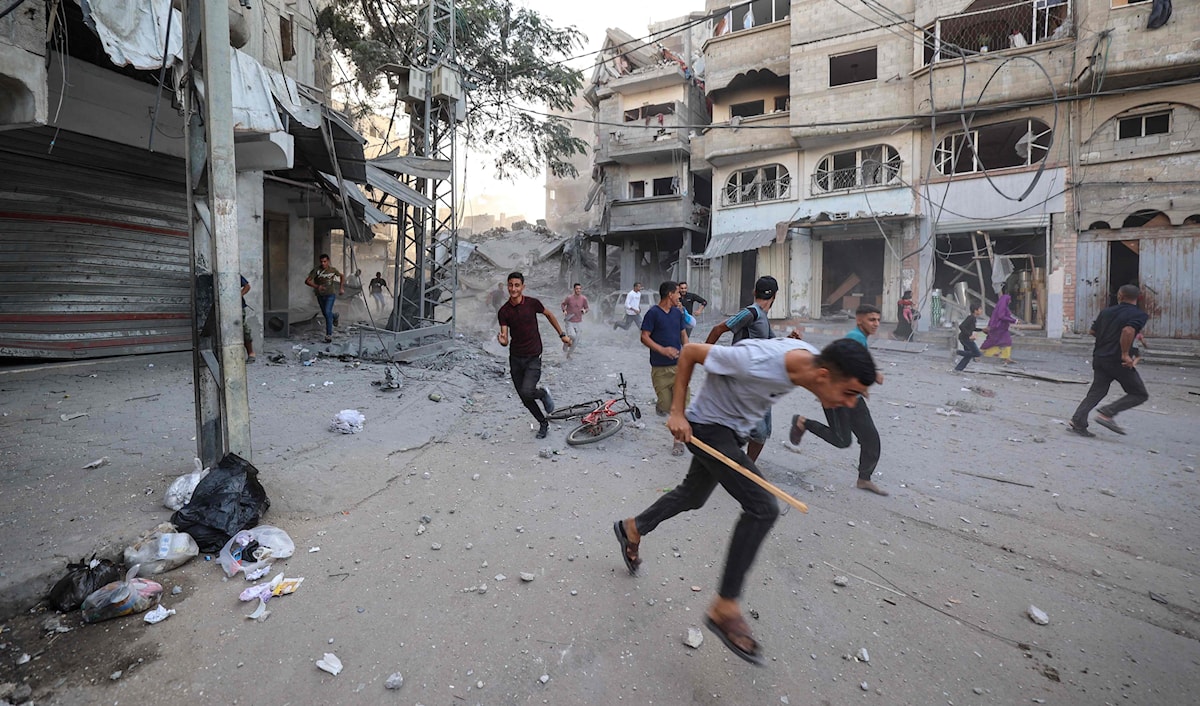 فلسطينيون يحاولون الاحتماء بعد غارة إسرائيلية على مبنى في مخيم البريج في وسط غزة (أ ف ب)