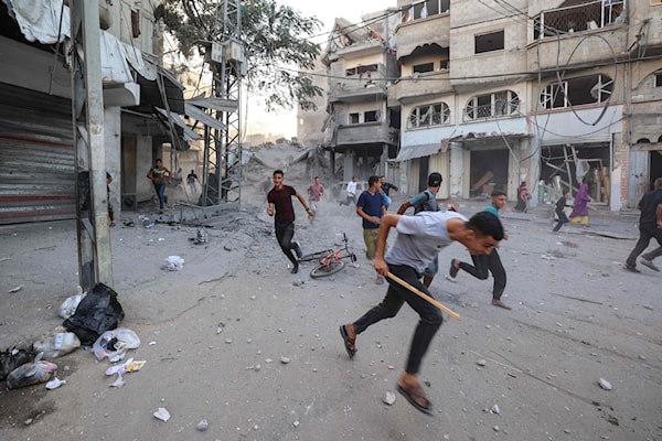 فلسطينيون يحاولون الاحتماء بعد غارة إسرائيلية على مبنى في مخيم البريج في وسط غزة (أ ف ب)