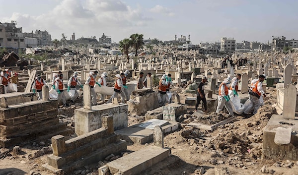 عناصر من الدفاع المدني يحملون جثامين بعض شهداء عائلة شحيبر لدفنها في مدينة غزة (أ ف ب)