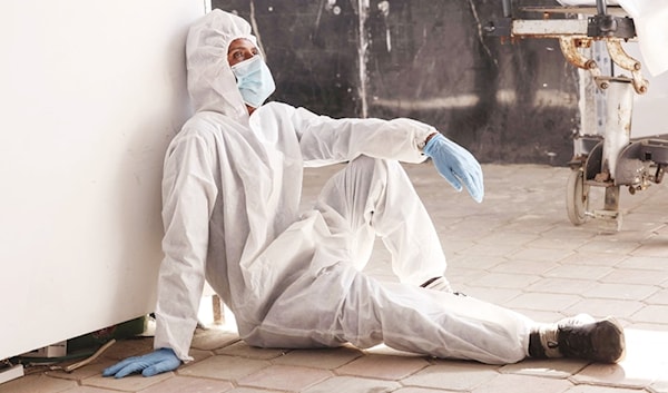 موظف في مستشفى «ناصر» في خانيونس يرتاح بعد إنزال جثامين 30 شهيداً فلسطينياً سلّمتها إسرائيل (أ ف ب)