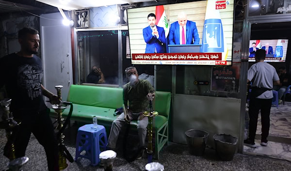 عراقيون يشاهدون في أحد مقاهي بغداد إعلان النتائج النهائية للانتخابات (أ ف ب)