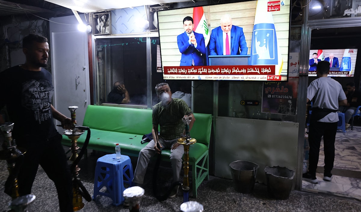 عراقيون يشاهدون في أحد مقاهي بغداد إعلان النتائج النهائية للانتخابات (أ ف ب)