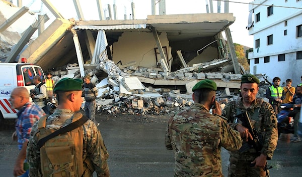 عناصر الجيش حول مبنى استهدفه العدو في بلدة دير كيفا أمس (أ ف ب)