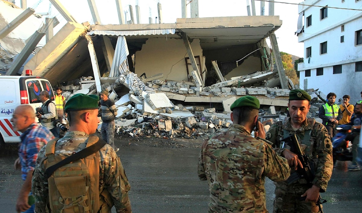 عناصر الجيش حول مبنى استهدفه العدو في بلدة دير كيفا أمس (أ ف ب)