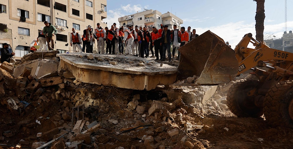 فرق الدفاع المدني تبحث عن جثث شهداء تحت أنقاض مبنى دُمر عام 2023 في حي الرمال بمدينة غزة (أ ف ب)