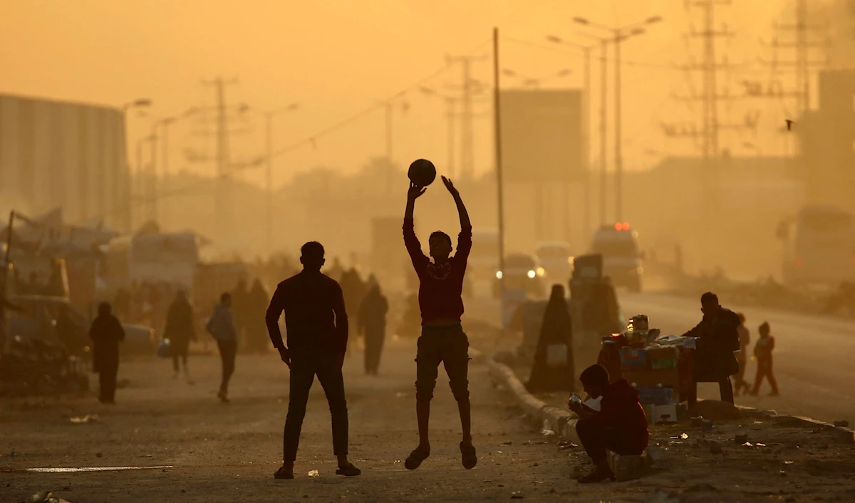 أطفال يلعبون بالكرة في مخيم النصيرات في قطاع غزة (أ ف ب)