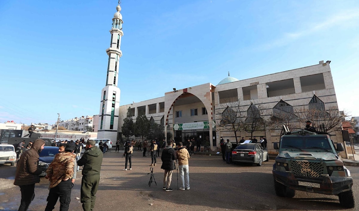 عناصرمن «الأمن العام» السوري أمام المسجد المستهدف في حمص (أ ف ب)