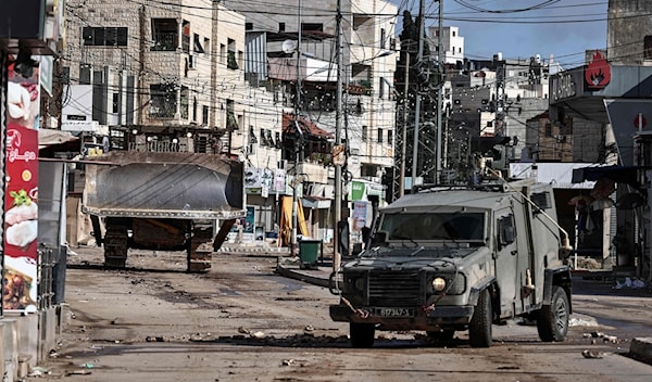 سيارة عسكرية وجرافة للاحتلال خلال اقتحام بلدة قباطية في الضفة الغربية (أ ف ب)
