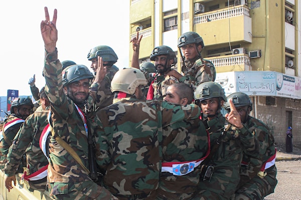 عناصر تابعون لـ «الانتقالي» يرفعون شارات النصر في عدن (أ ف ب)