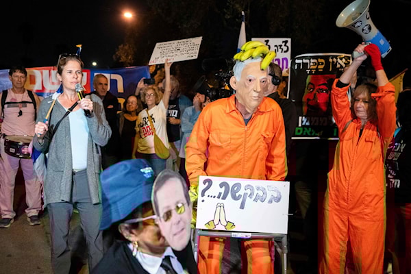 محتجون على طلب نتنياهو العفو، أمام منزل هيرتسوغ، في تل أبيب (أ ف ب)