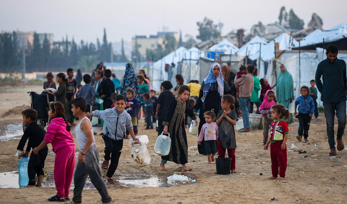 فلسطينيون يصطفون لتعبئة مياه الشرب في مخيم النصيرات وسط قطاع غزة (أ ف ب)
