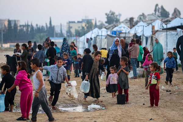 فلسطينيون يصطفون لتعبئة مياه الشرب في مخيم النصيرات وسط قطاع غزة (أ ف ب)
