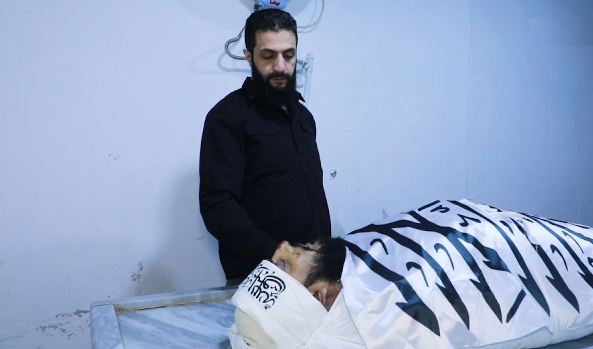 الشرع (الجولاني) أمام جثة القحطاني بعد مقتله في انفجار استهدفه في سرمدا (من الويب)