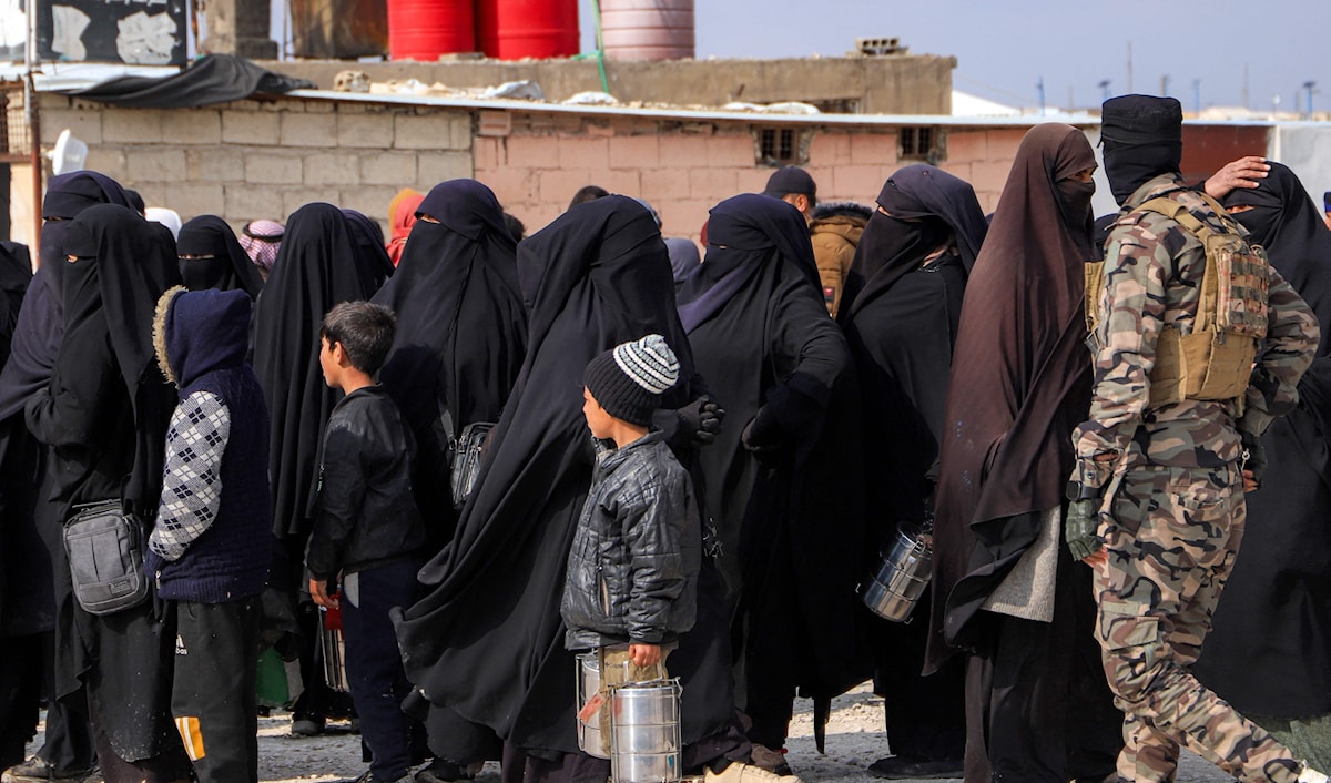 عنصر من «قسد» يحرس عوائل لأسرى تنظيم «داعش» في مخيم الهول في الحسكة (أ ف ب)