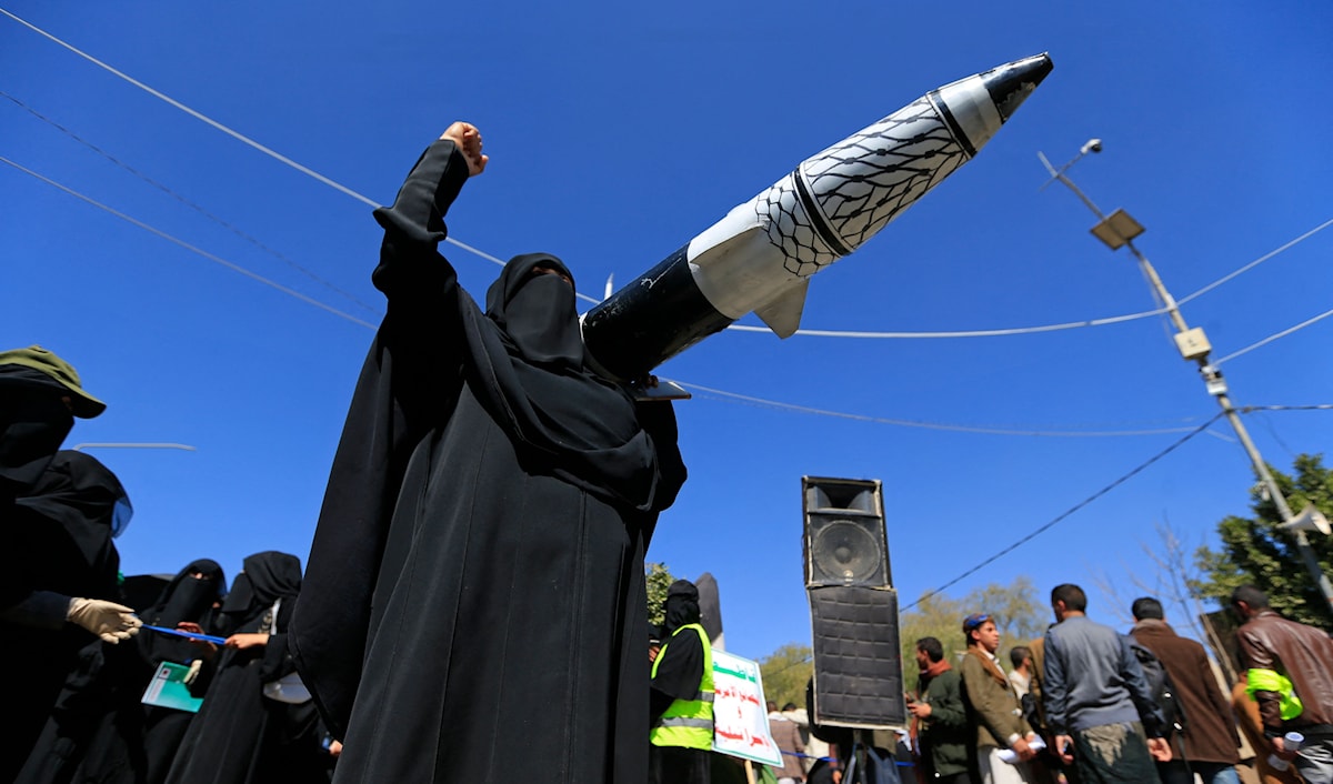 يمنية تحمل نموذج صاروخ خلال تظاهرة تأييد لحركة "أنصار الله" في صنعاء (أ ف ب)