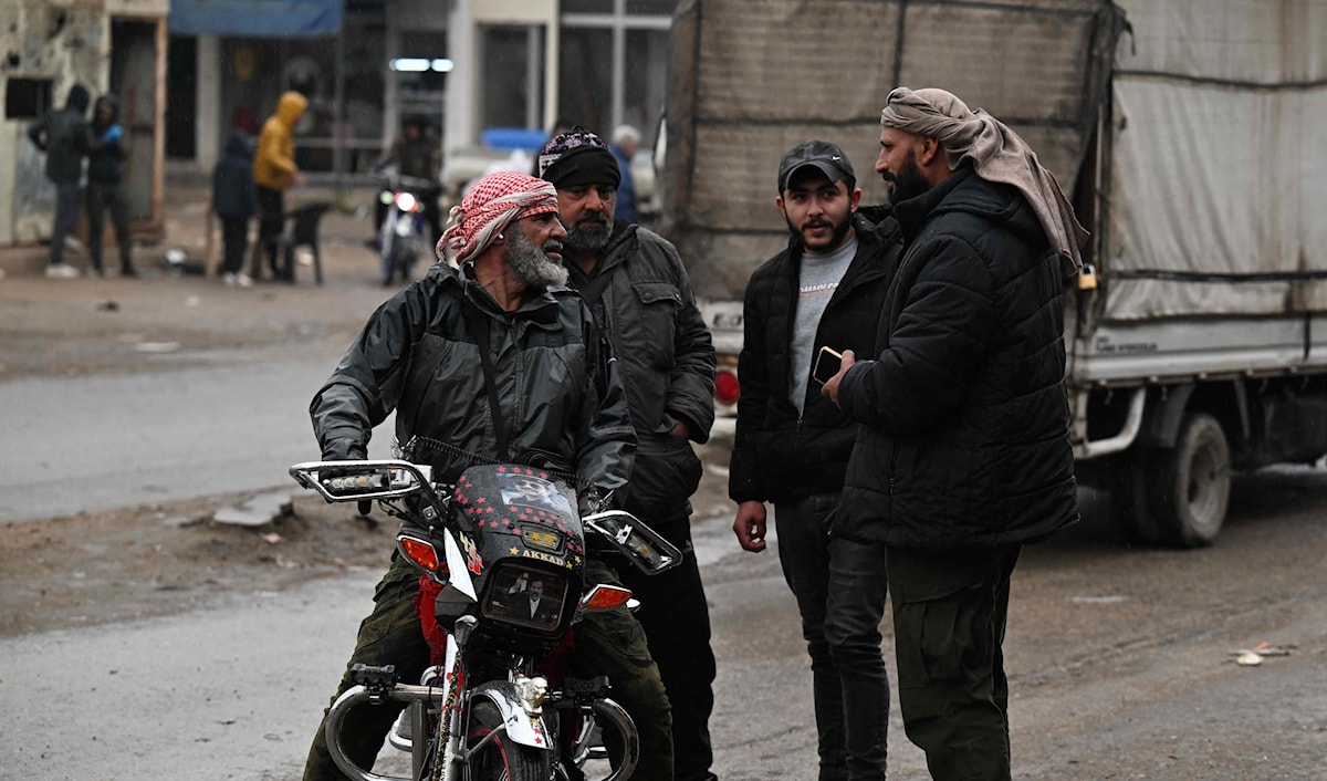 مقاتلون تابعون للإدارة السورية الجديدة يتحادثون في بابا عمرو في حمص (أ ف ب)