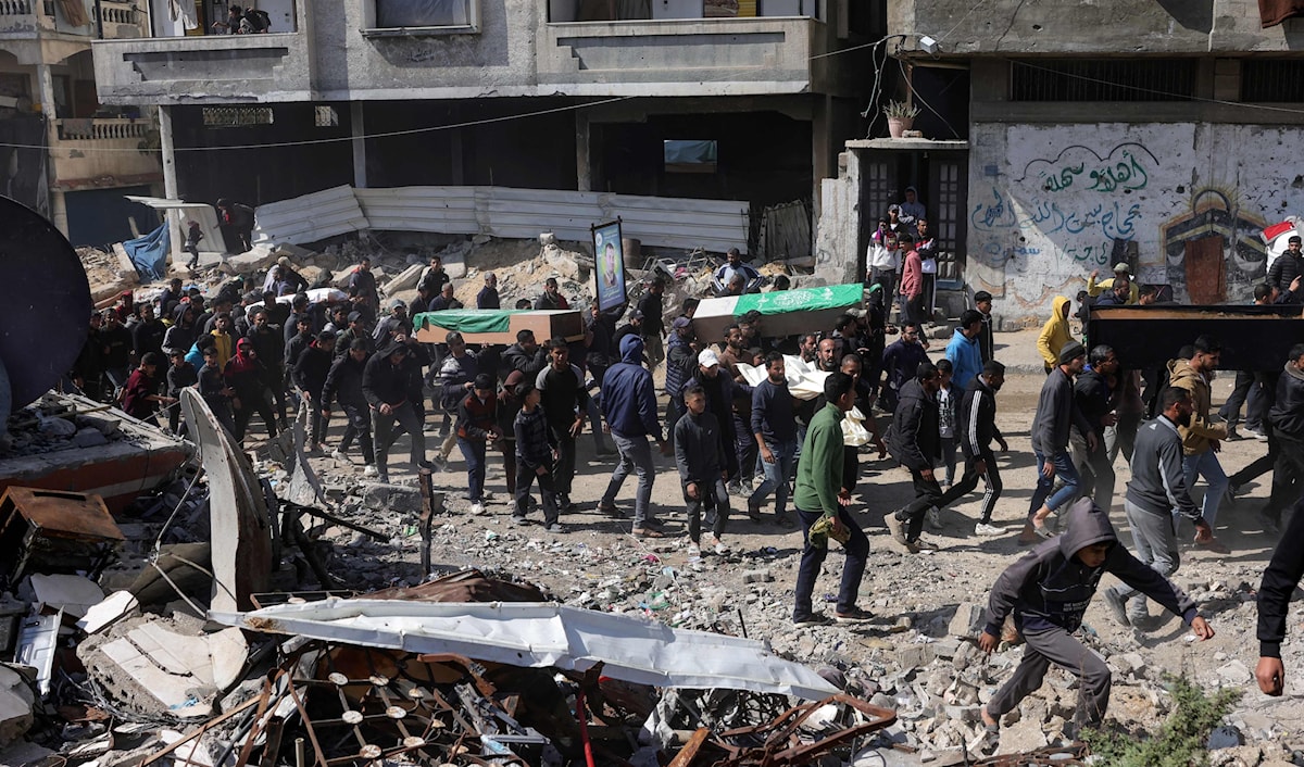فلسطينيون بينهم عناصر من "حماس" يشيعون شهداء سقطوا خلال العدوان الإسرائيلي في مخيم الشاطئ في قطاع غزة (أ ف ب)