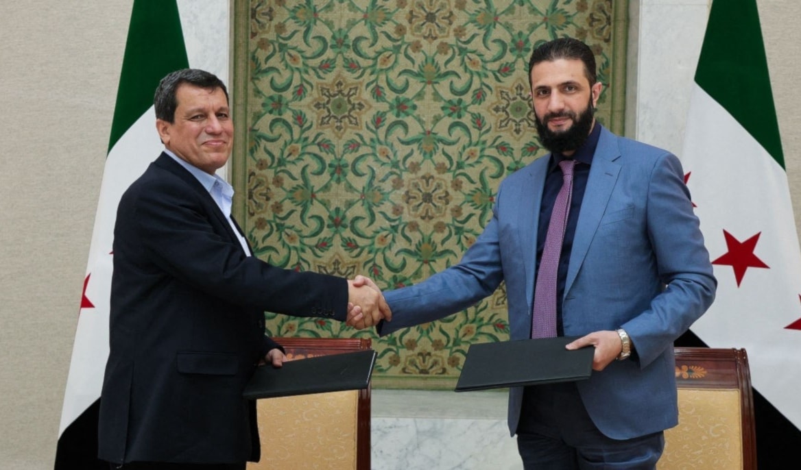 الشرع وعبدي يتبادلان نسختين موقّعتين من الاتفاق في دمشق أمس (أ ف ب)