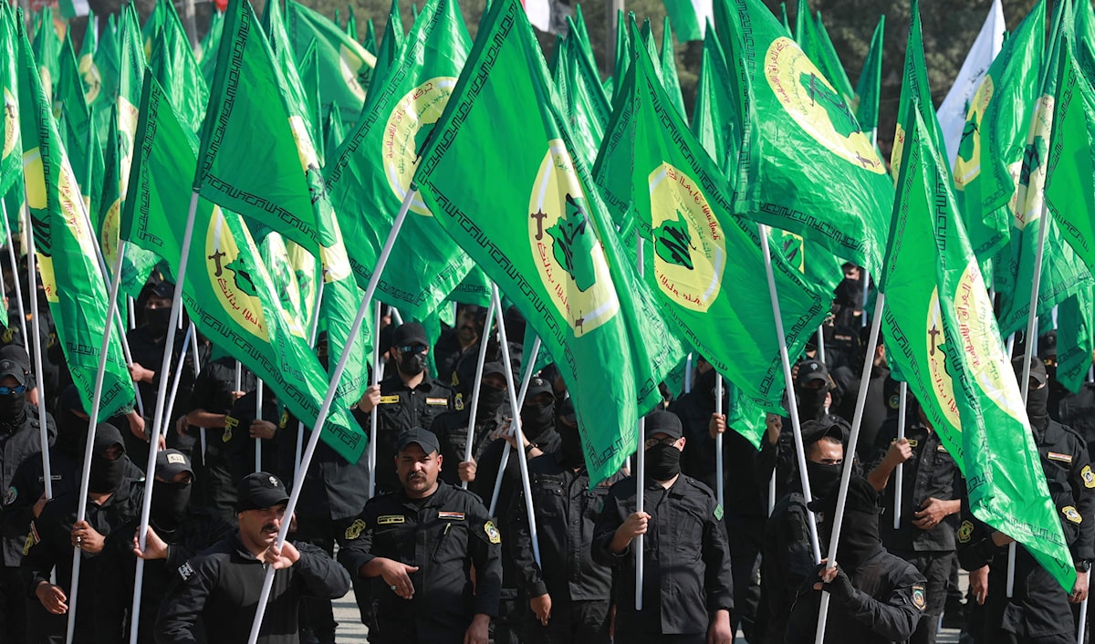مقاتلون من "الحشد الشعبي" يرفعون أعلاماً في بغداد (أ ف ب)