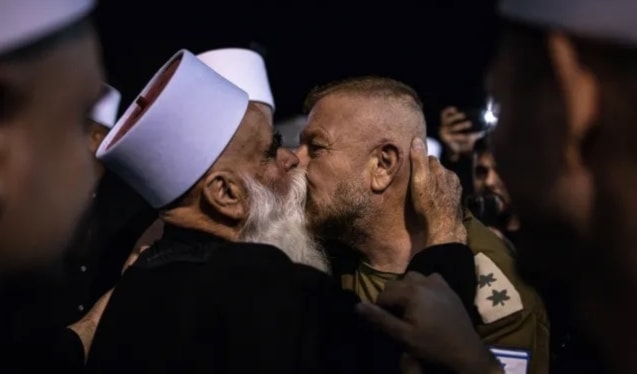 رجل دين درزي سوري يُقبّل جندياً إسرائيلياً لدى وصوله إلى «مقام النبي شعيب» في آذار الماضي (أ ف ب)