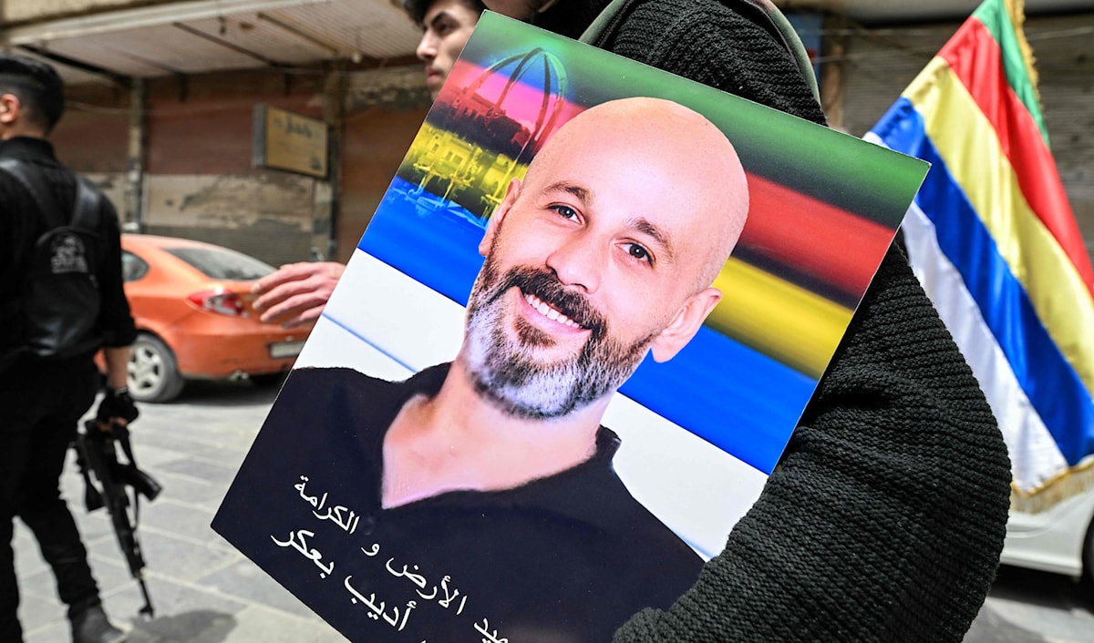 درزي يحمل صورة أحد ضحايا اشتباكات جرمانا (أ ف ب)