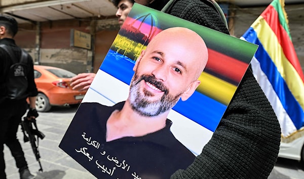 درزي يحمل صورة أحد ضحايا اشتباكات جرمانا (أ ف ب)