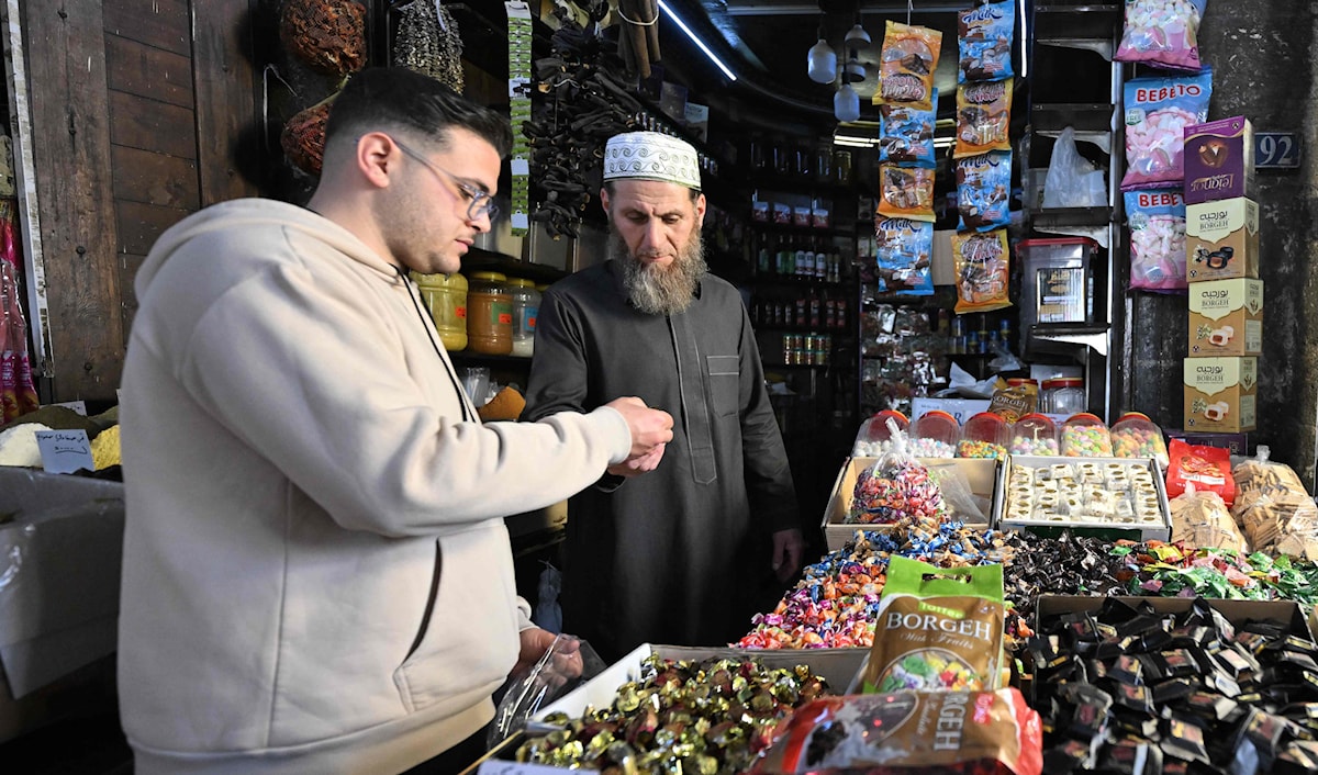 متسوّق يشتري حلويات في سوق الحميدية في دمشق (أ ف ب)
