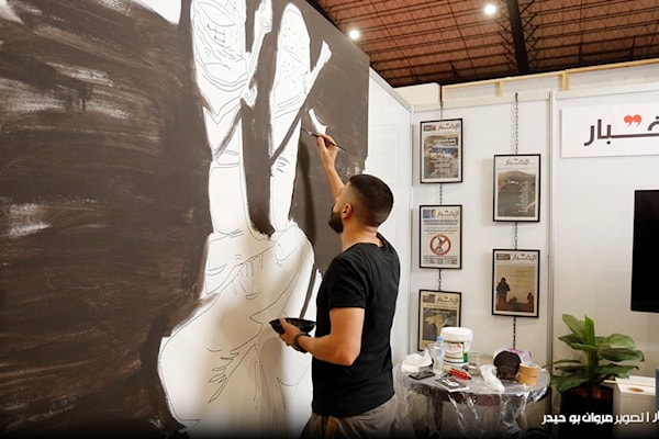 الزميل نهاد علم الدين، في رسم جدارية عن المقاومة الفلسطينية.