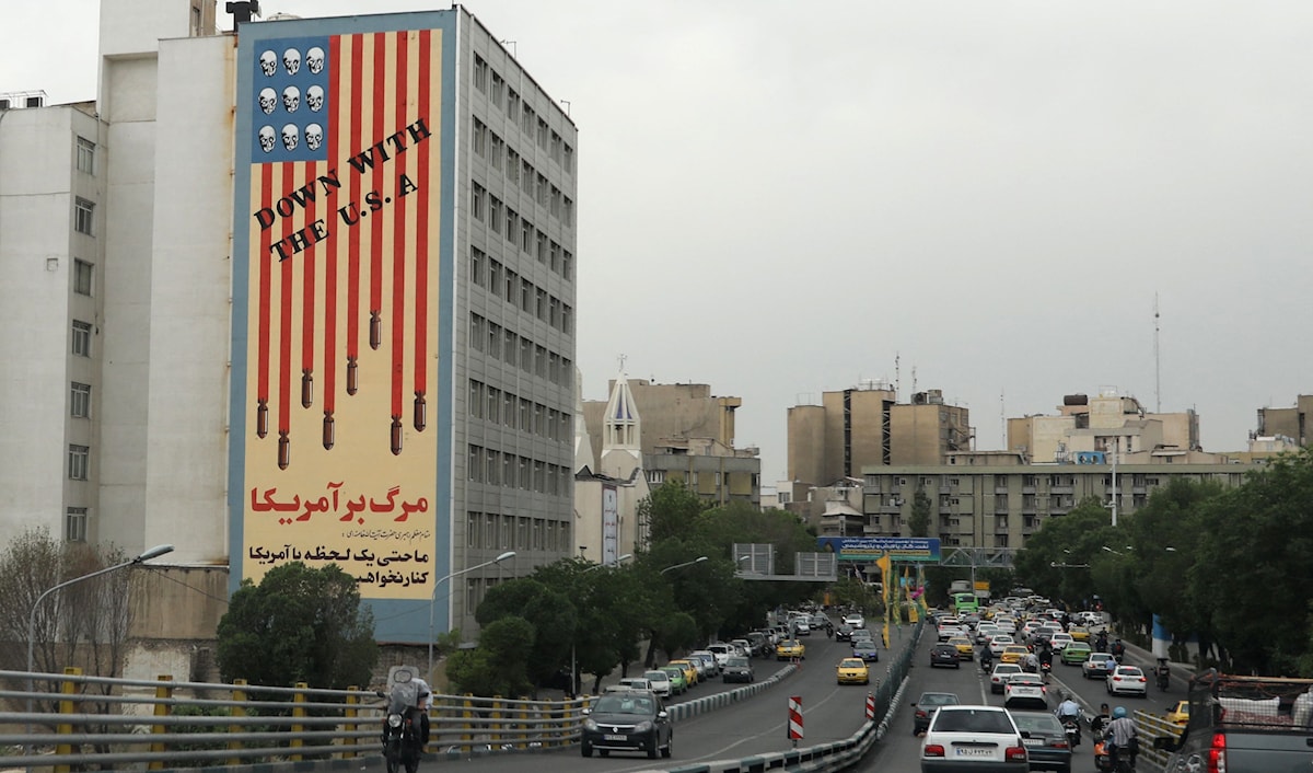 جدارية في طهران تصوّر العلم الأميركي مع جماجم بدل النجوم وعبارة "فلتسقط أميركا" (أ ف ب)