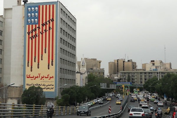جدارية في طهران تصوّر العلم الأميركي مع جماجم بدل النجوم وعبارة "فلتسقط أميركا" (أ ف ب)