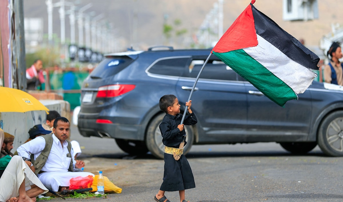 طفل يمني يرفع علماً فلسطينياً في صنعاء (أ ف ب)