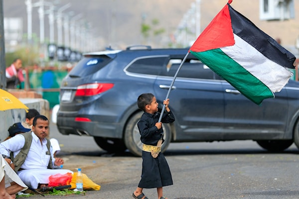 طفل يمني يرفع علماً فلسطينياً في صنعاء (أ ف ب)