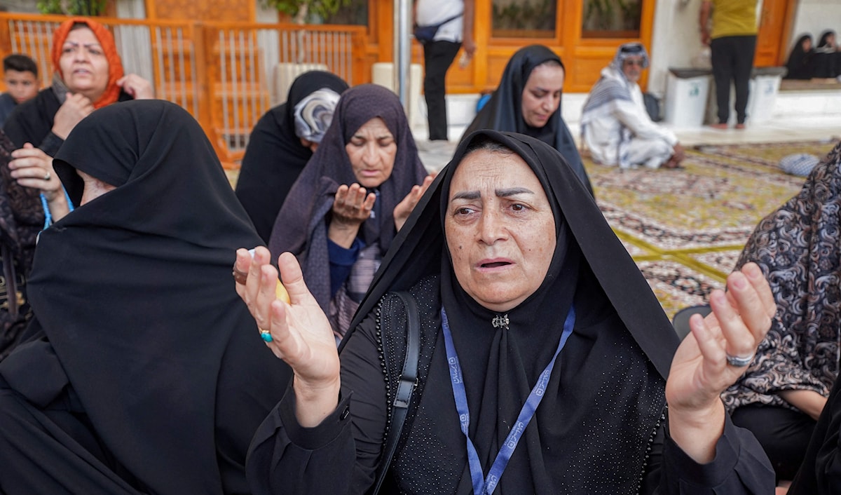 إيرانيات يبتهلن بعد سماعهن ببدء العدوان الإسرائيلي، خلال زيارة إلى مرقد الإمام علي في النجف (أ ف ب)