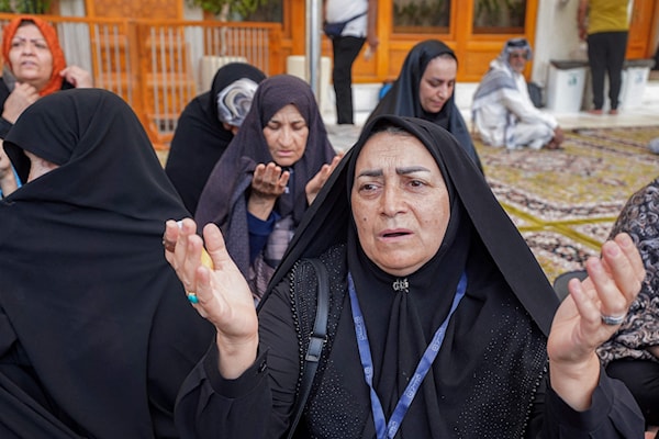 إيرانيات يبتهلن بعد سماعهن ببدء العدوان الإسرائيلي، خلال زيارة إلى مرقد الإمام علي في النجف (أ ف ب)