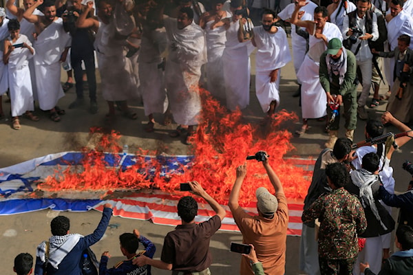 يمنيون يحرقون علمي أميركا وإسرائيل في صنعاء (أ ف ب)