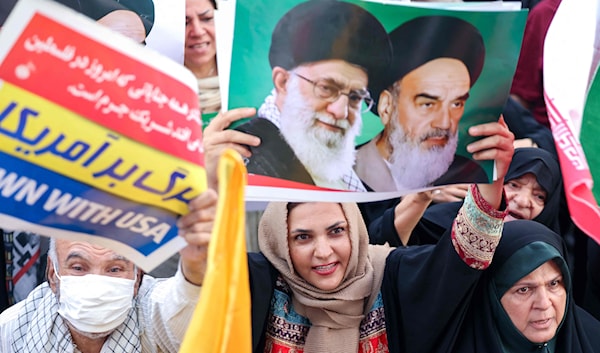 صورة الخامنئي والخميني مرفوعة في طهران أثناء احتفال بالانتصار (أ ف ب)