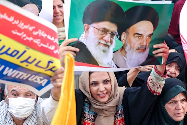 صورة الخامنئي والخميني مرفوعة في طهران أثناء احتفال بالانتصار (أ ف ب)