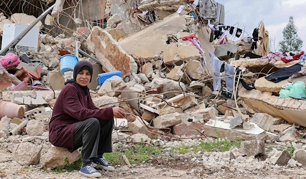 امرأة عند دمار بيتها في قرية الوزاني الجنوبية (بعدسة ربيع ظاهر، وكالة فرانس برس، 2025)