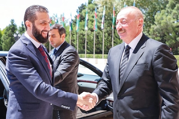 الرئيس الأذربيجاني، إلهام علييف، مستقبلاً نظيره السوري الانتقالي، أحمد الشرع، في باكو (أ ف ب)