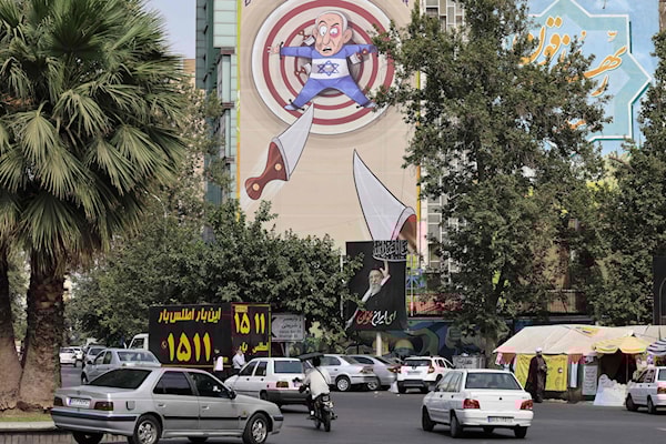 رسم يسخر من رئيس وزراء العدو، بنيامين نتنياهو، في طهران (أ ف ب)