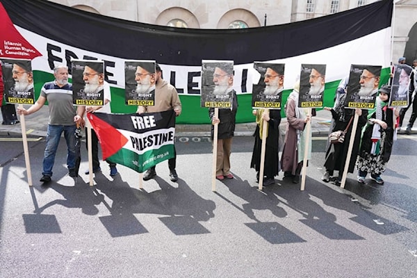 ناشطو حقوق إنسان يرفعون صور الخامنئي خلال مسيرة من أجل فلسطين أمام مقر رئاسة الحكومة البريطانية في لندن (أ ف ب)