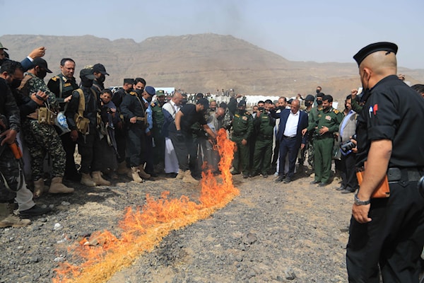 عناصر أمن يمنيون يحرقون مواد ممنوعة في صنعاء (أ ف ب)