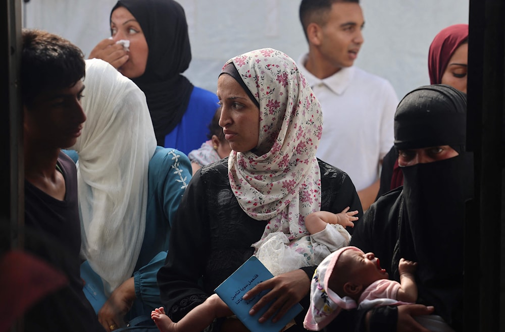 فلسطينيون ينتظرون مع أطفالهم لتلقي العلاج في نقطة طبية تابعة لوزارة الصحة الفلسطينية في خانيونس (أ ف ب)