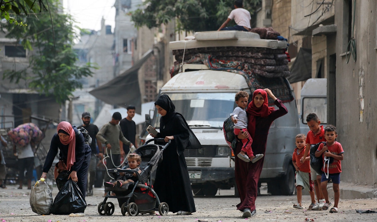 فلسطينيون يهربون بما تيسّر من أمتعة من حي أبو إسكندر في شمال غزة (أ ف ب)