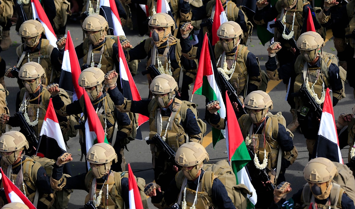 عسكريون يمنيون يحملون أعلام فلسطين خلال عرض في صنعاء (أ ف ب)